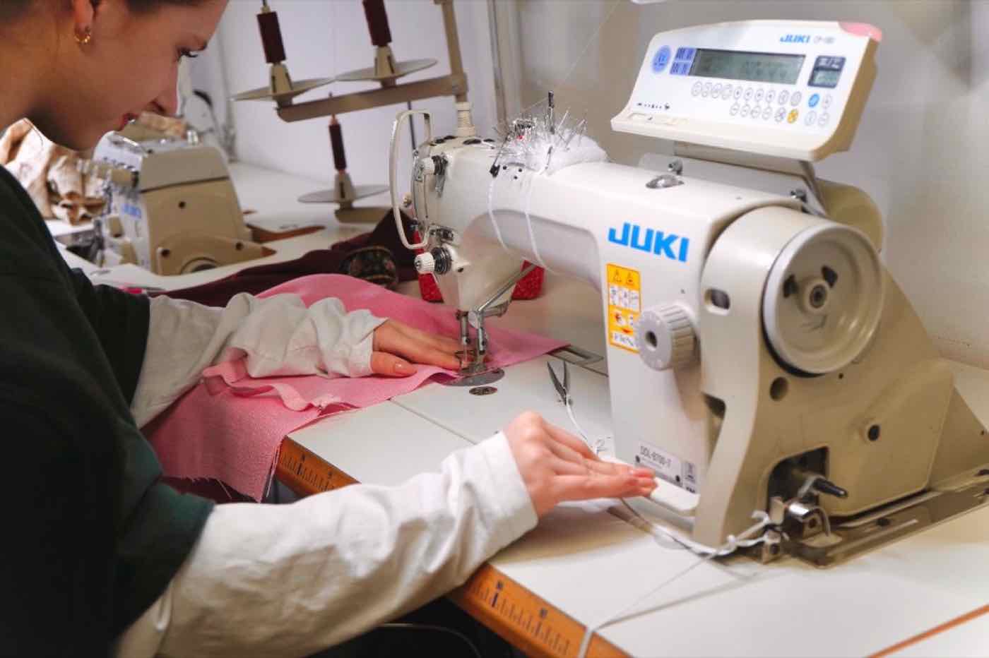 Hände einer Kursteilnehmerin an der JUKI-Nähmaschine beim Nähworkshop